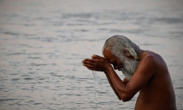 Hindu sadhu celebrating Holi festival on Ganga river Varanasi India colorful spiritual culture India